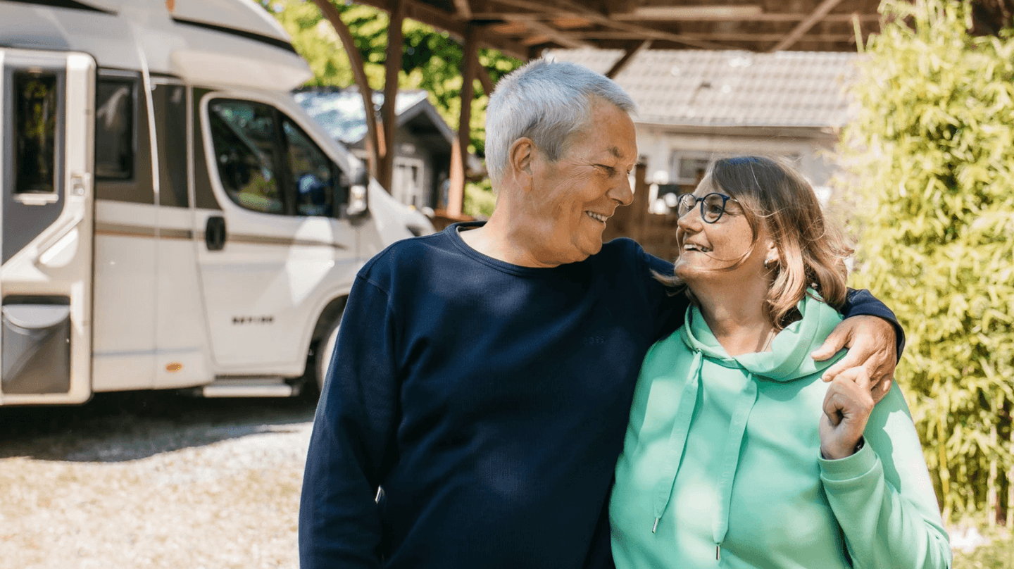 Ehepaar steht vor ihrem Wohnmobil